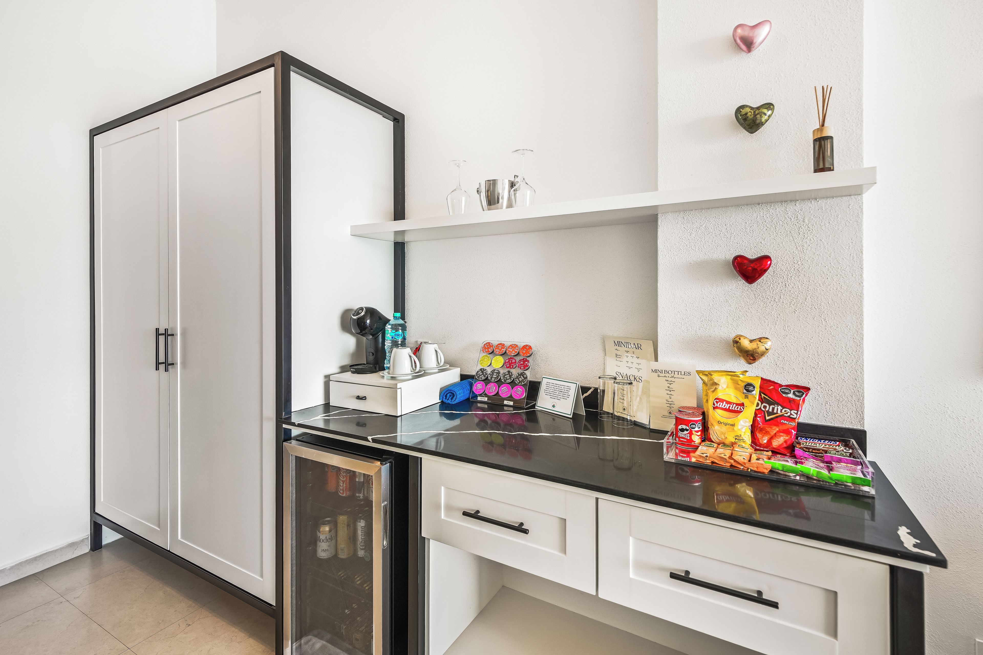 A modern kitchen with a black countertop, white cabinets, and a built-in dishwasher.