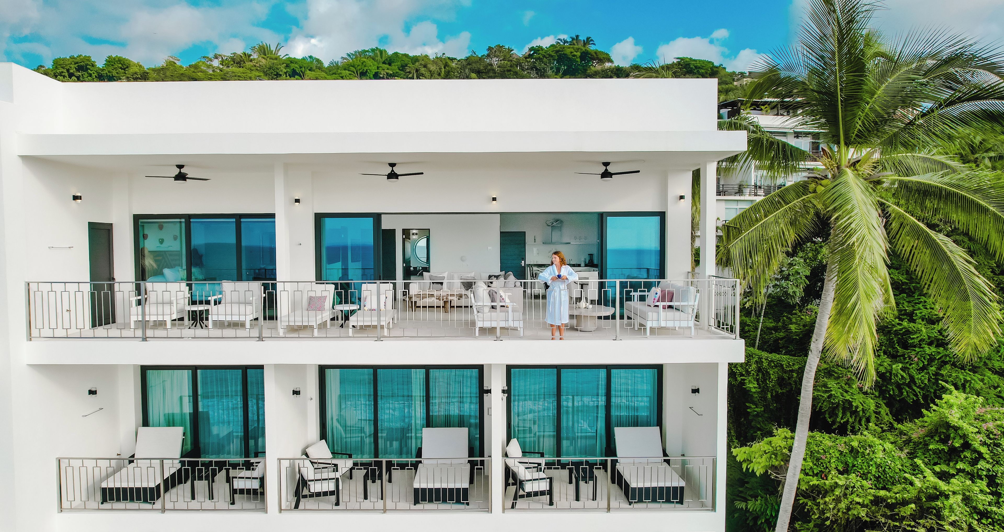 A multi-story hotel with balconies, outdoor seating, and a pool area.