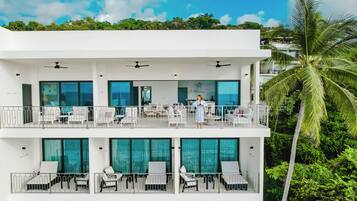 A multi-story hotel with balconies, outdoor seating, and a pool area.