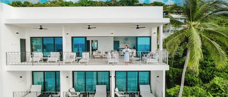 A multi-story hotel with balconies, outdoor seating, and a pool area.