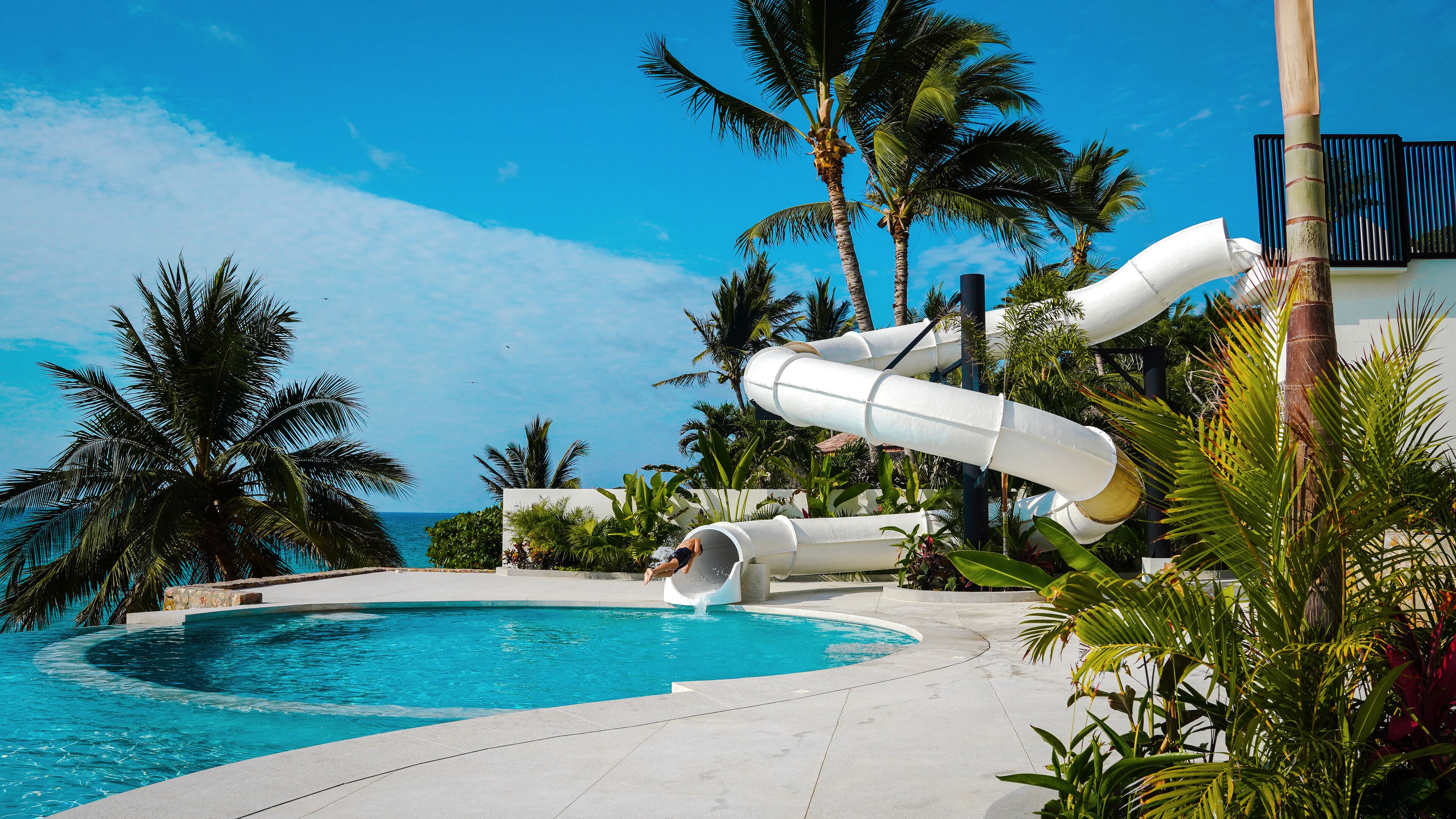 Una piscina al aire libre, sombrillas, tumbonas