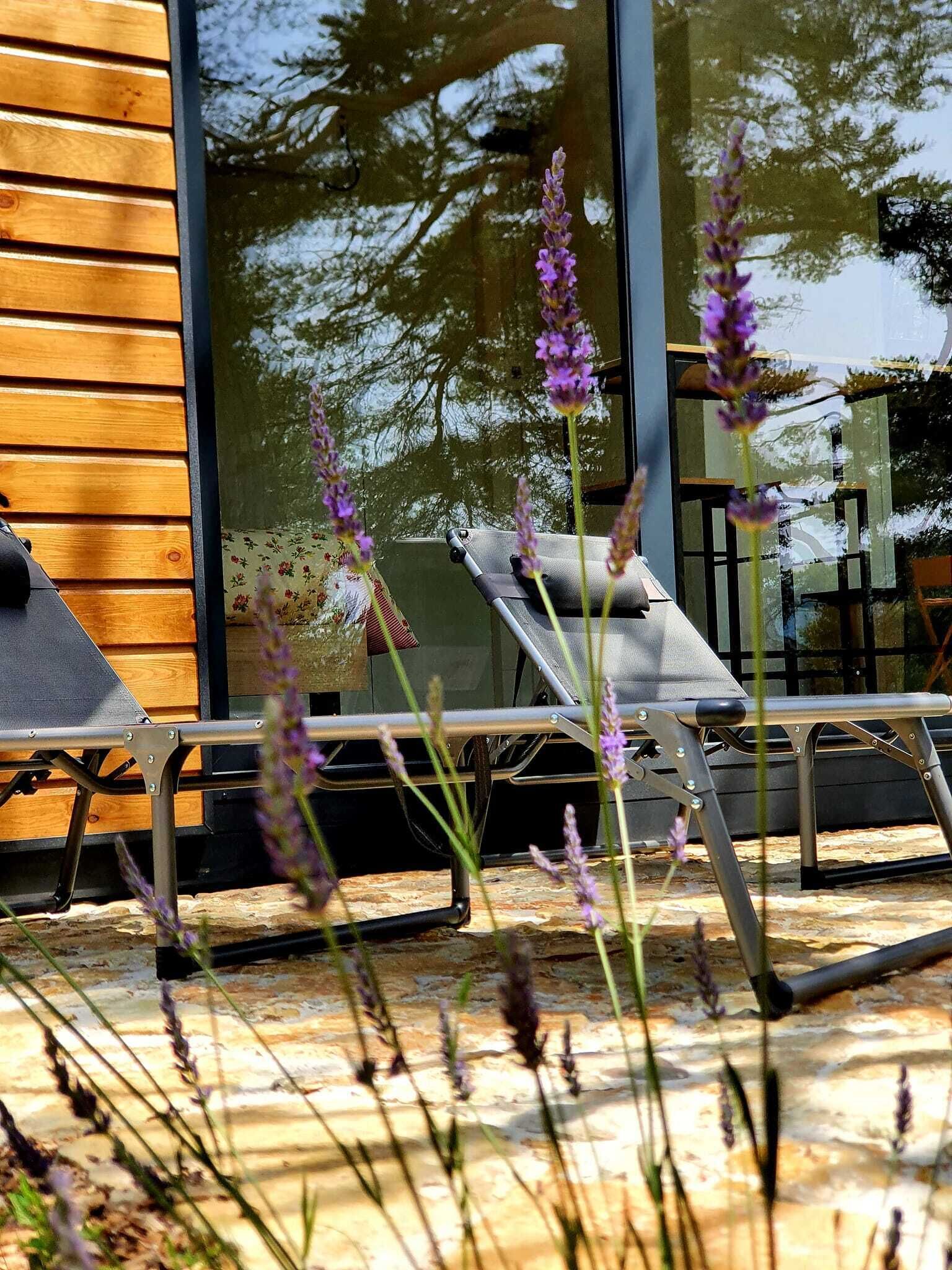 A wooden exterior wall, a glass door, and a metal chair with a cushion.
