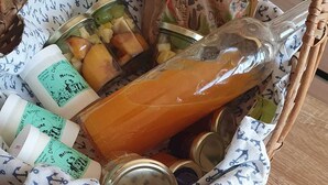 Una cesta de mimbre llena de alimentos y tres recipientes blancos con preparaciones al horno.