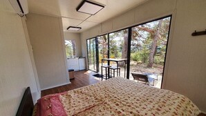 Un dormitorio con una cama grande, un escritorio y vistas al exterior.