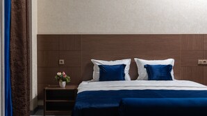 A bedroom with a large bed, a nightstand, and a blue upholstered bench. - Reikartz Abis Tashkent (Tashkent)