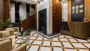 A modern lobby with a reception desk, a staircase, and a patterned floor. - Reikartz Abis Tashkent (Tashkent)