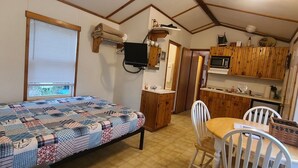 A compact room with a bed, a small dining table, a microwave, and a sink. - The Captains Quarters at Northside Marina & Resort (chico)