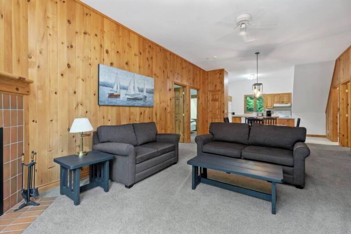 A living room with two sofas, a coffee table, and a painting on the wall.