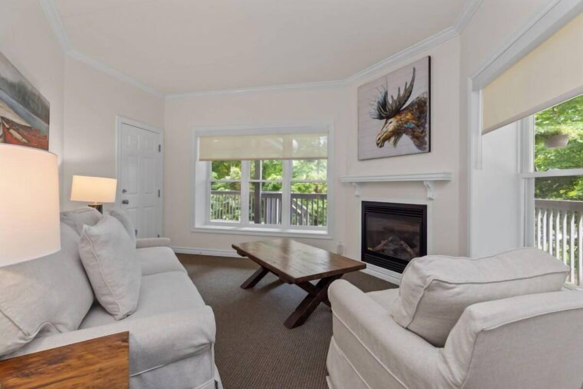 A living room with a fireplace, a sofa, a coffee table, and a painting on the wall.