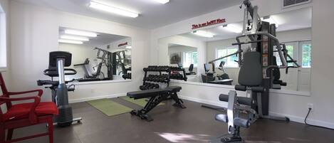 A gym with exercise equipment, a red chair, and a sign that says "This is our happy place".