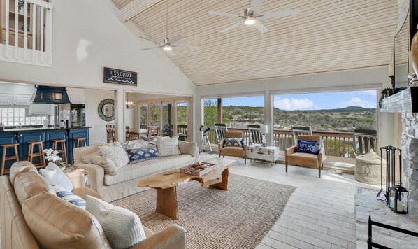 A spacious living area with a large sofa, coffee table, and a view of the outdoors.