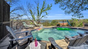 A swimming pool with lounge chairs and a slide, surrounded by a wooden fence and trees. - Lake Home with Private Pool, Games, Views! 100 yds to Marina w boat launch! (Strawn)