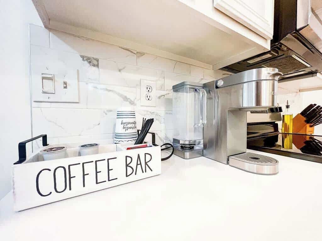Una cocina con un letrero de cafetería, una máquina de café y un hervidor.