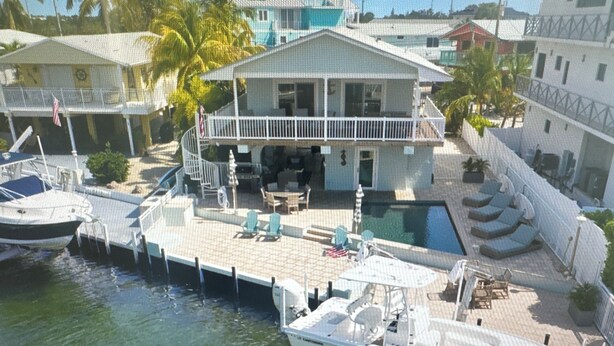 Ein vertäutes Boot, ein Schwimmbecken und ein Gebäude mit einem Balkon.