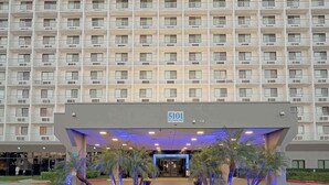 Hotel de varios pisos con una entrada amplia, número 5101, y un cartel que dice 'Welcome'.