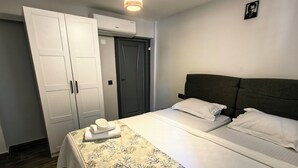 A hotel room with a bed, a wardrobe, and a ceiling light. - Demirtaş Pansiyon (Bozcaada)