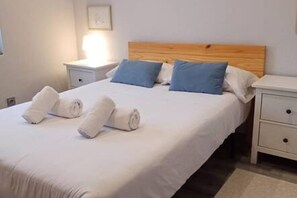 A hotel room with a bed, two bedside tables, and a nightstand. - 175A La Arena 3-Bedroom Apartment by R2R Consulting (Gijón)