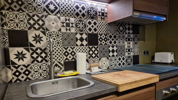 A kitchen with patterned tiles, a stainless steel sink, a cutting board, and a toaster. - 184A Apartment in the La Arena neighborhood by R2R (Gijón)