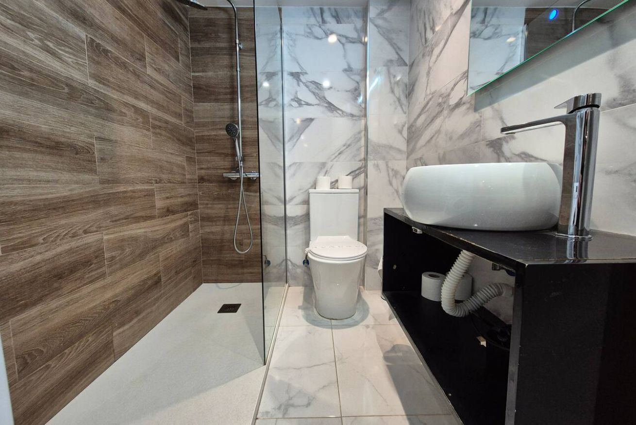 A modern bathroom with a shower, toilet, and vanity.