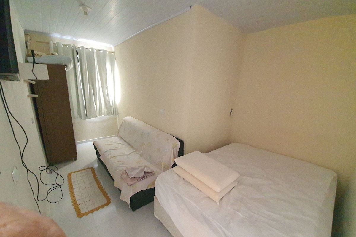 Un dormitorio con dos camas, un escritorio y una ventana con cortinas.