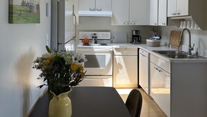 Una cocina moderna con armarios blancos, una isla central y un tragaluz.