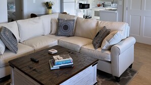 Una sala moderna con un sofá modular, una mesa de centro y un ventilador de techo.
