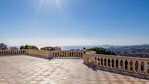 A terrace with a tiled floor and balustrades, overlooking a cityscape and the sea. - Architectural jewel between sea and mountains (Teià)