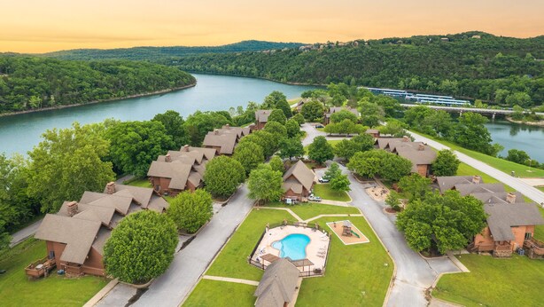 A resort with multiple cottages, a swimming pool, and a river view. - Table Rock Landing Resort (Eureka Springs)