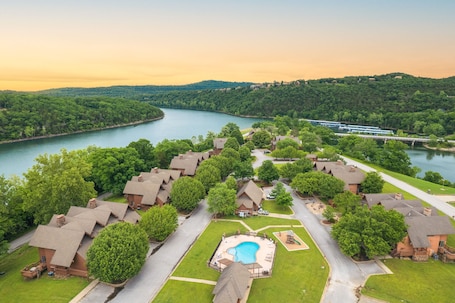 A resort with multiple cottages, a swimming pool, and a river view.