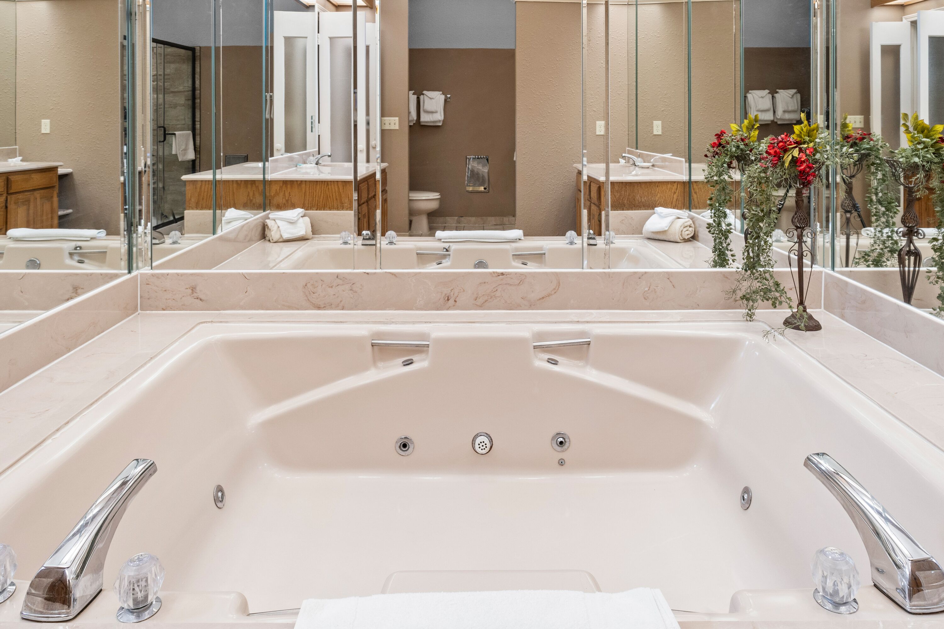 Un baño moderno con una bañera grande, dos lavamanos y un espejo.