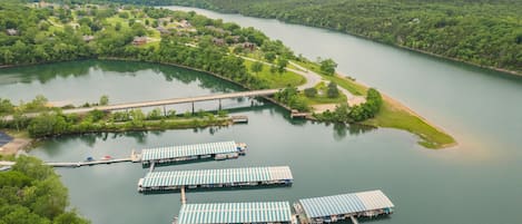 A riverside view with a bridge, docked boats, and a residential area.