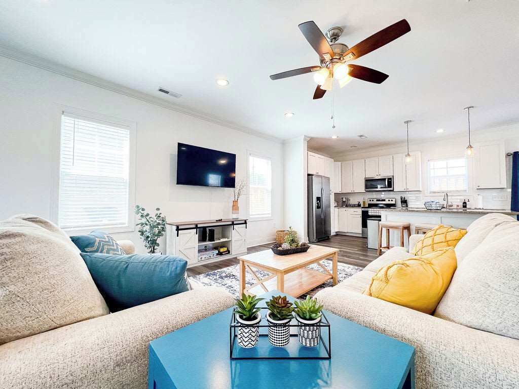 Ein modernes Wohnzimmer mit Sofa, Couchtisch und Deckenventilator.