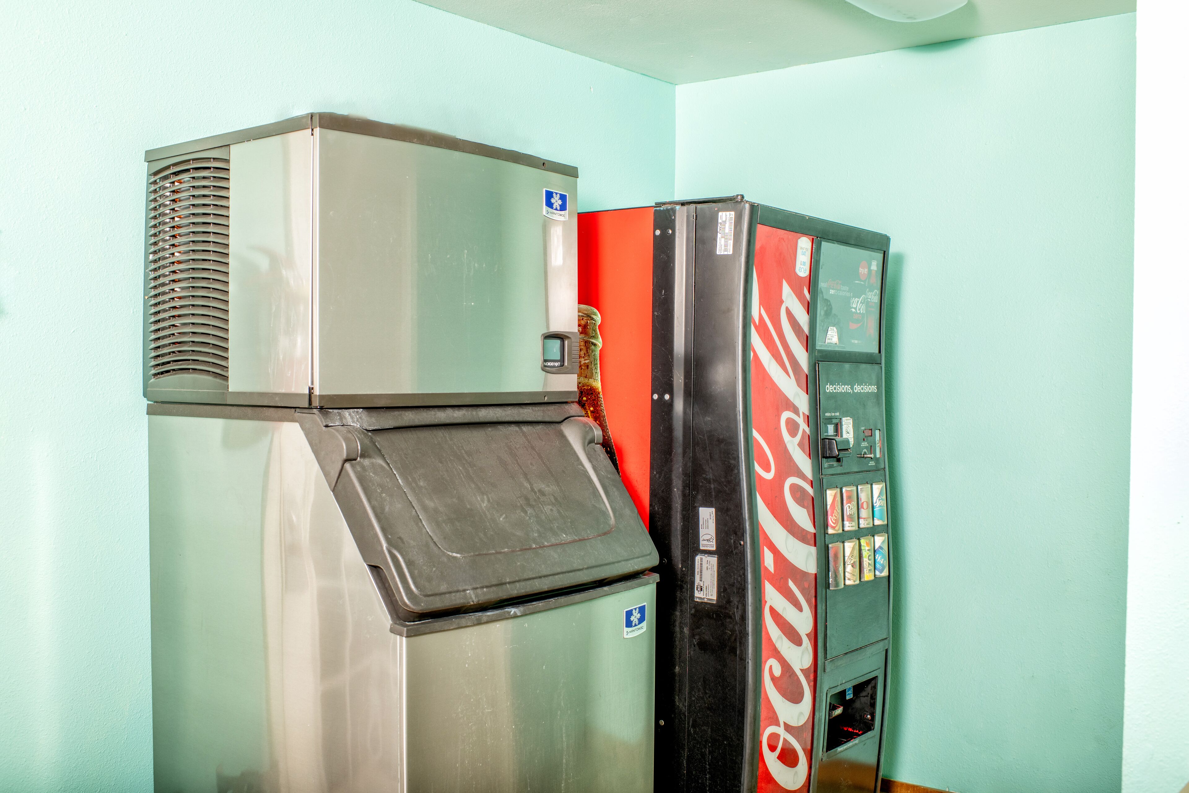 Un distributeur automatique orné du logo Coca-Cola, un réfrigérateur et un radiateur.