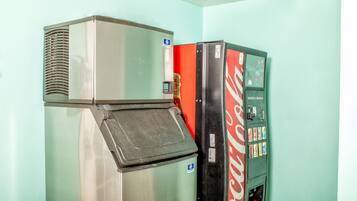 Un distributeur automatique orné du logo Coca-Cola, un réfrigérateur et un radiateur.