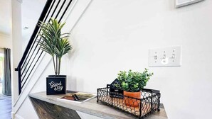 Una escalera moderna con barandilla de madera y pasamanos de metal negro.