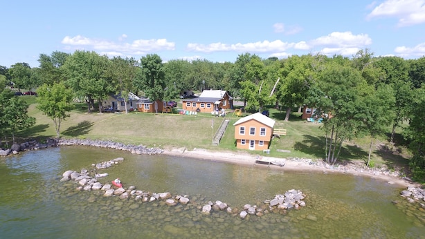 A house with a clear view of the surrounding landscape, including a pond with rocks and a wooden dock. - Quiet Northwoods Cabin on Leech Lake, Minnesota (Federal Dam)