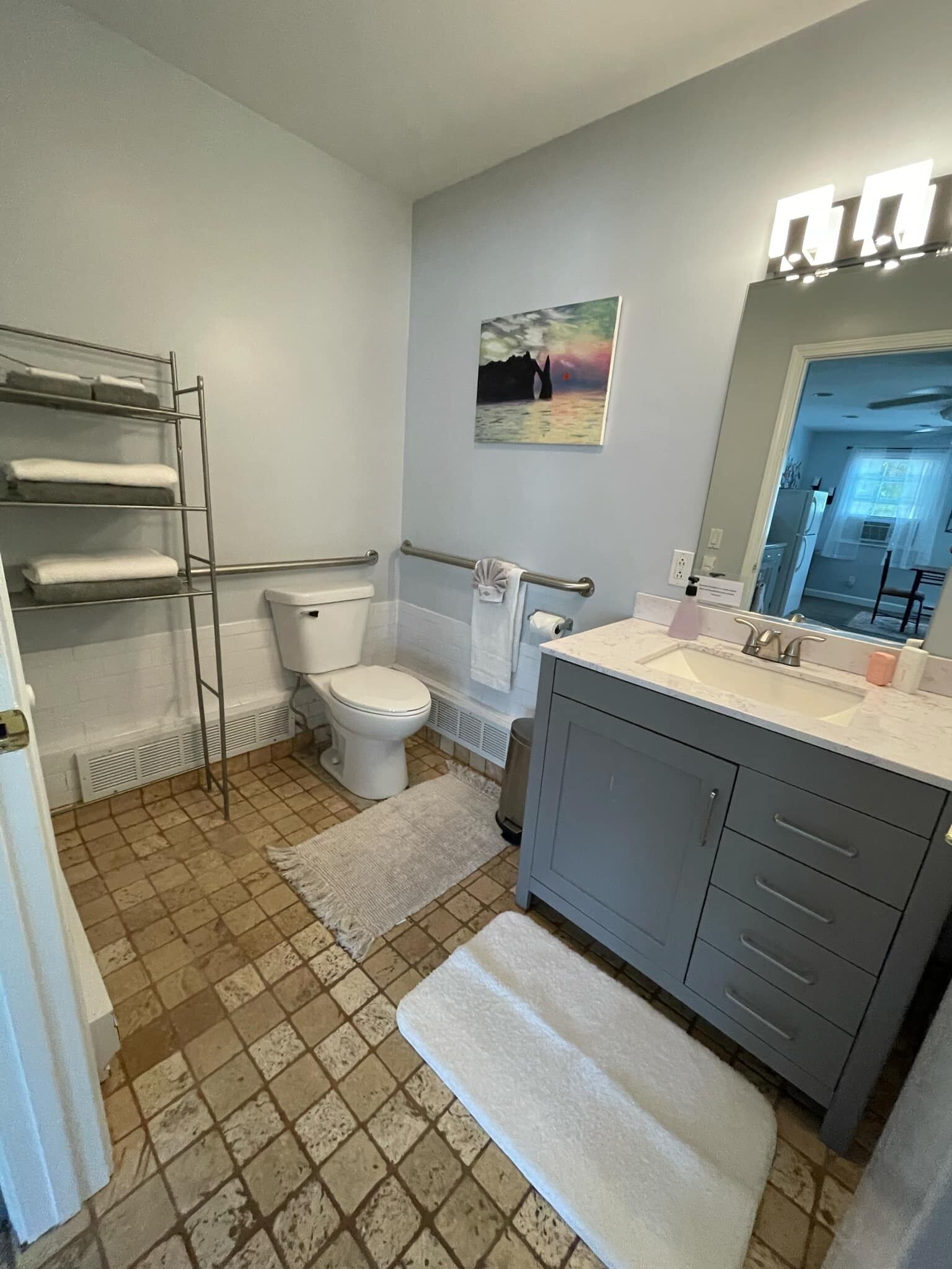 A bathroom with a toilet, sink, and towel rack.