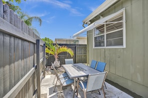 Enjoy dining or socializing in this patio area with a table and chairs.
