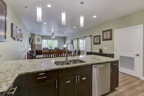 A modern kitchen with granite countertops, stainless steel appliances, and pendant lighting. - GORGEOUS 3-BEDROOM LUXURY CONDO/HEART OF BRANSON/INDOOR POOL/SPACIOUS/NO-STEPS! (Branson)
