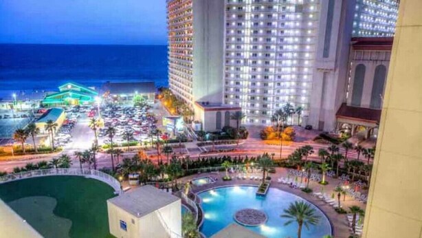 A hotel with a pool area, a view of the ocean, and a parking lot. - The Lazy Place: Gulf Penthouse, High Ceiling &Bunk (Panama City Beach)