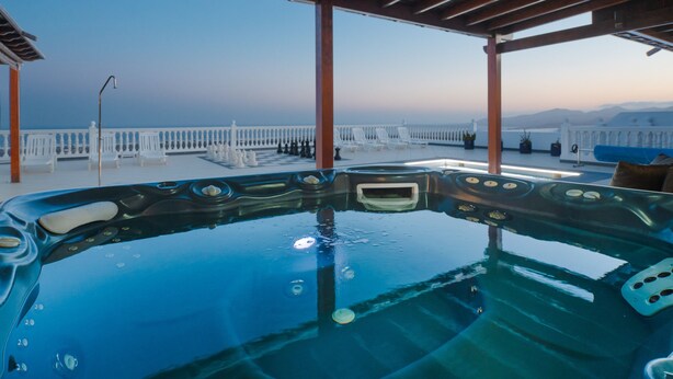 Un jacuzzi con vistas despejadas al mar y montañas al fondo.