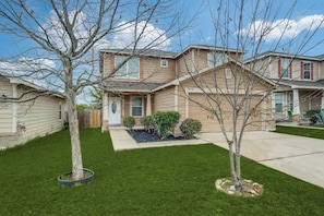 Two-story house with a garage and a well-manicured lawn.