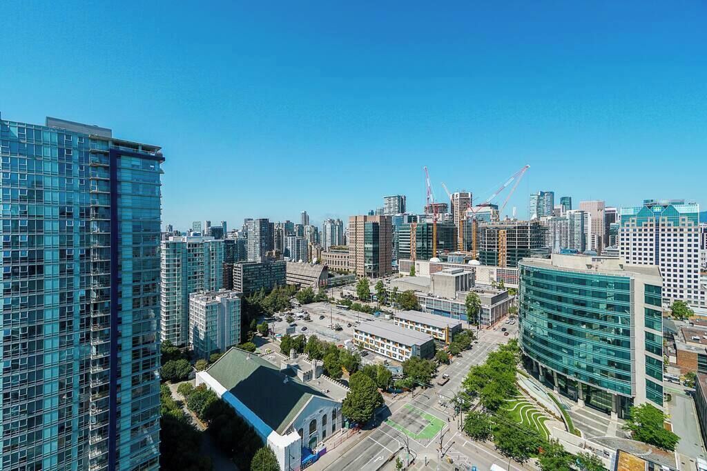 Un paisaje urbano con modernos rascacielos, una combinación de edificios comerciales y residenciales, y grúas de construcción a la vista.