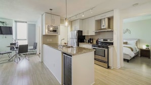 A modern kitchen with a central island, built-in appliances, and a dining area with a TV.