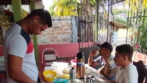 Un espacio de comedor al aire libre cubierto, con una mesa lista para una comida.