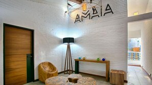 A modern interior with a white brick wall, a wooden door, a floor lamp, and a small table with decorative items.