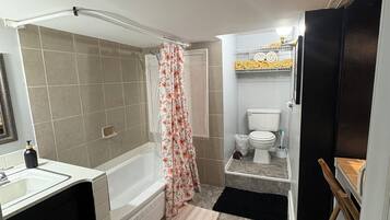 Een badkamer met een bad, toilet en wastafel.
