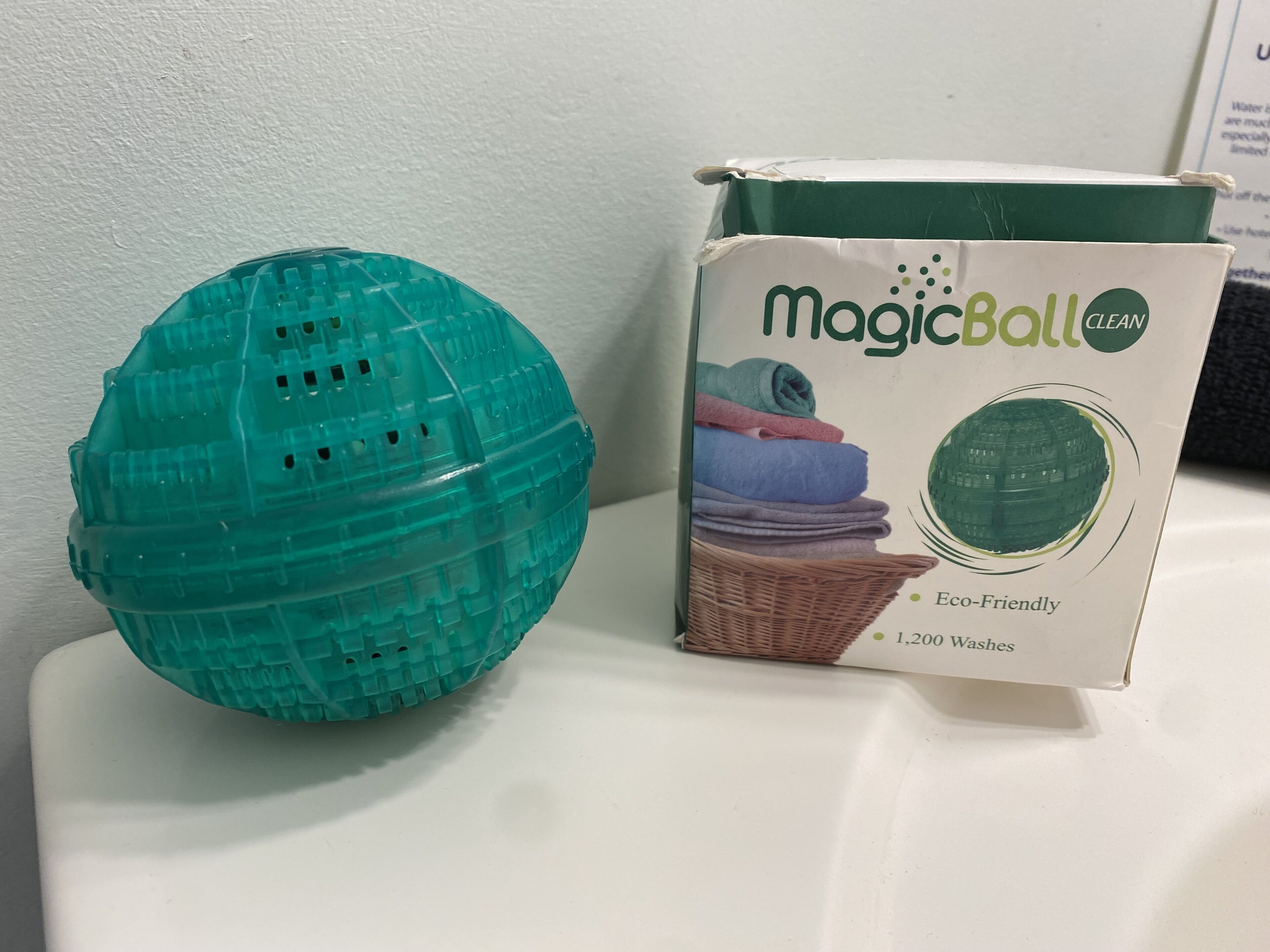 En turkis MagicBall CLEAN vasketøjskurv og emballage.