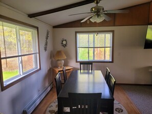 A dining area with a table, chairs, a ceiling fan, and windows with blinds. - Relaxing Lake View Home, Pet Friendly, Central Location.  Close to Ferries! (St. Ignace)