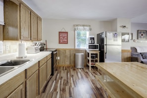 A kitchen with wooden cabinets, a microwave, a refrigerator, and a coffee maker. - Lakefront Phelps Cabin w/ Boat Dock & Water Toys! (Phelps)